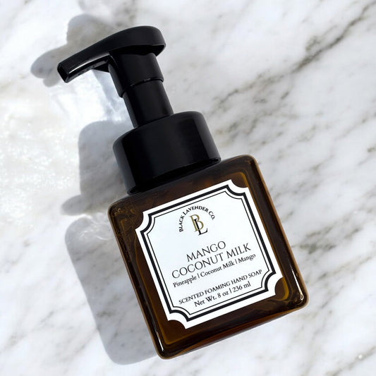 Foaming hand soap bottle labeled 'Mango Coconut Milk' on a marble surface