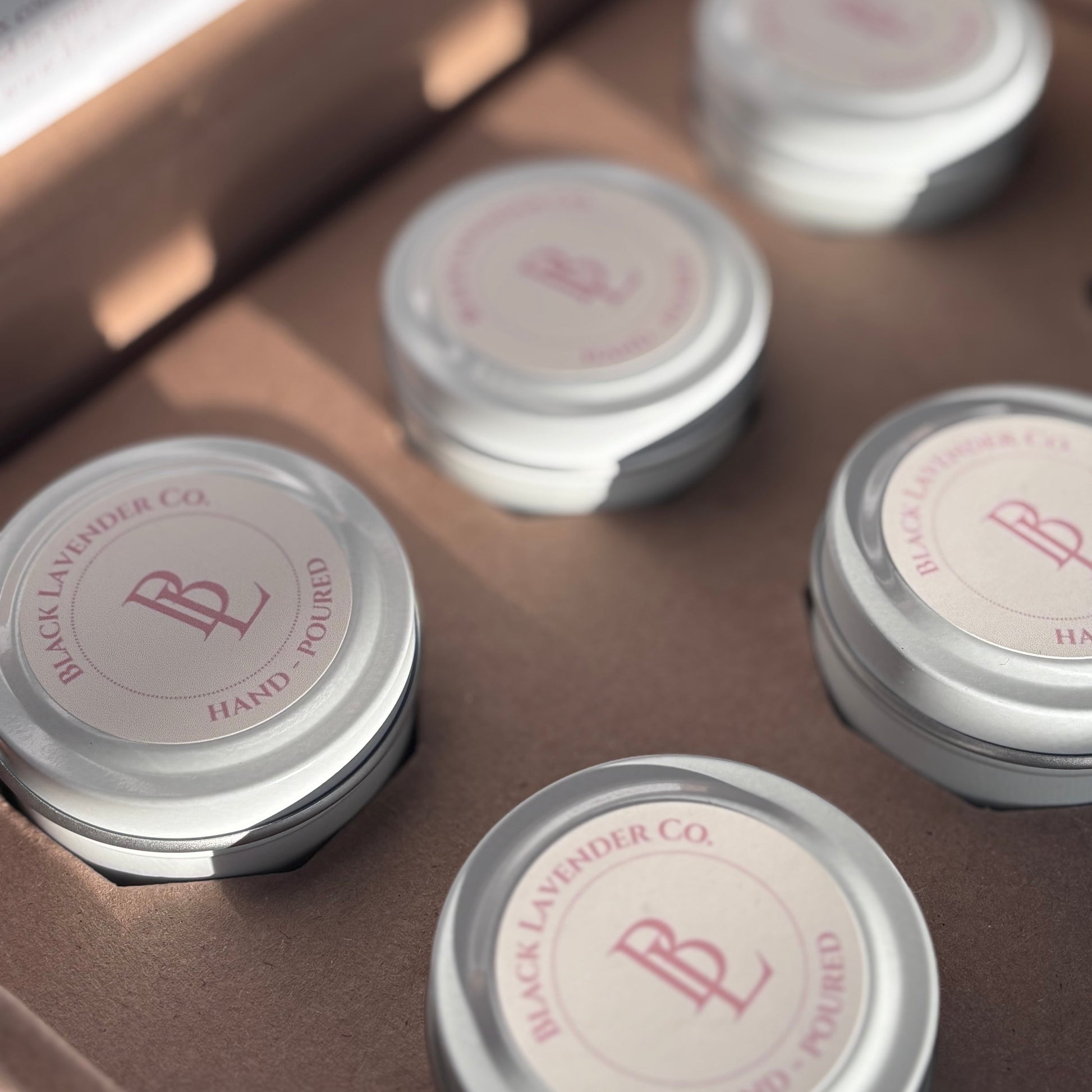 White tins with pink lids on a brown surface
