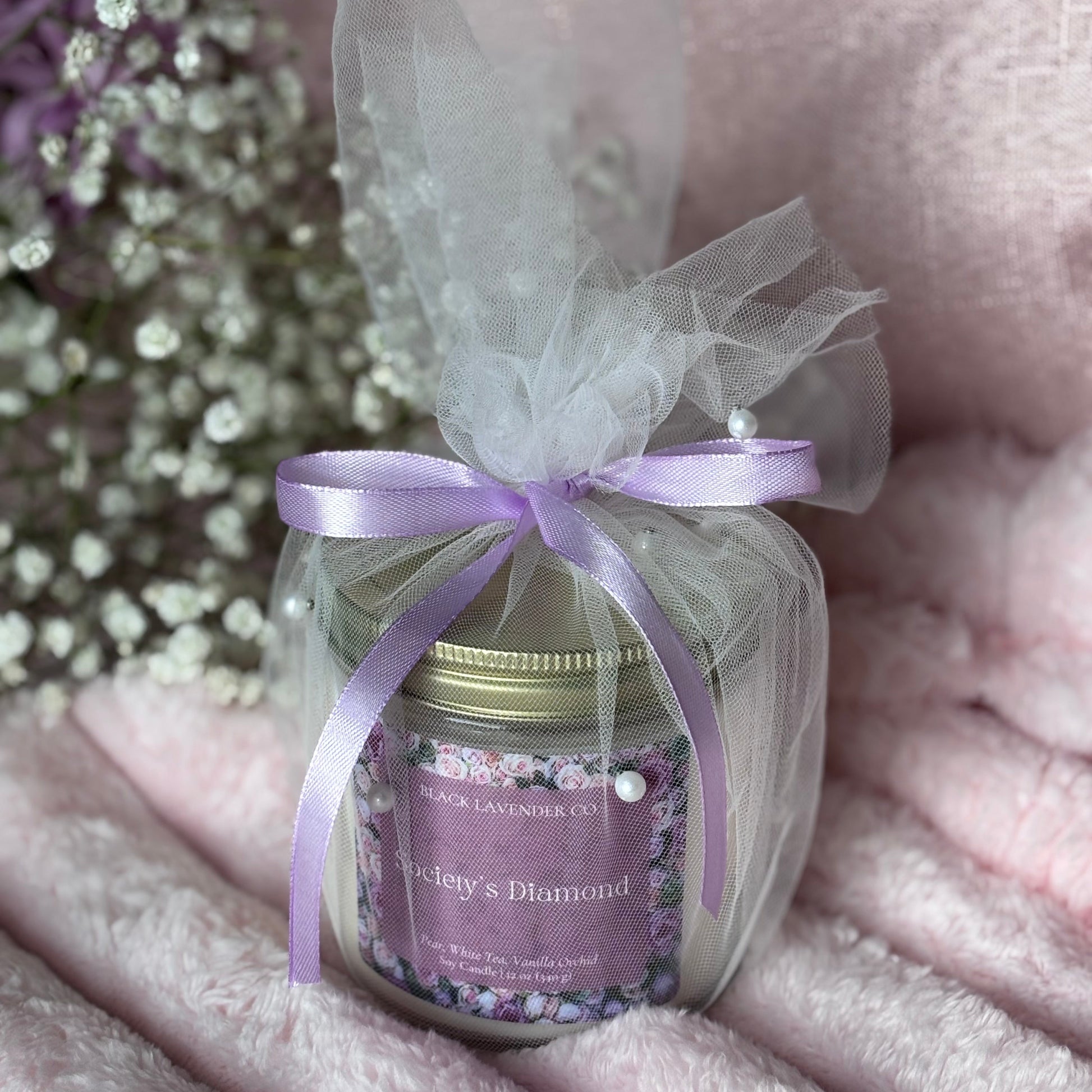 Small jar with a purple label and ribbon on a soft pink surface