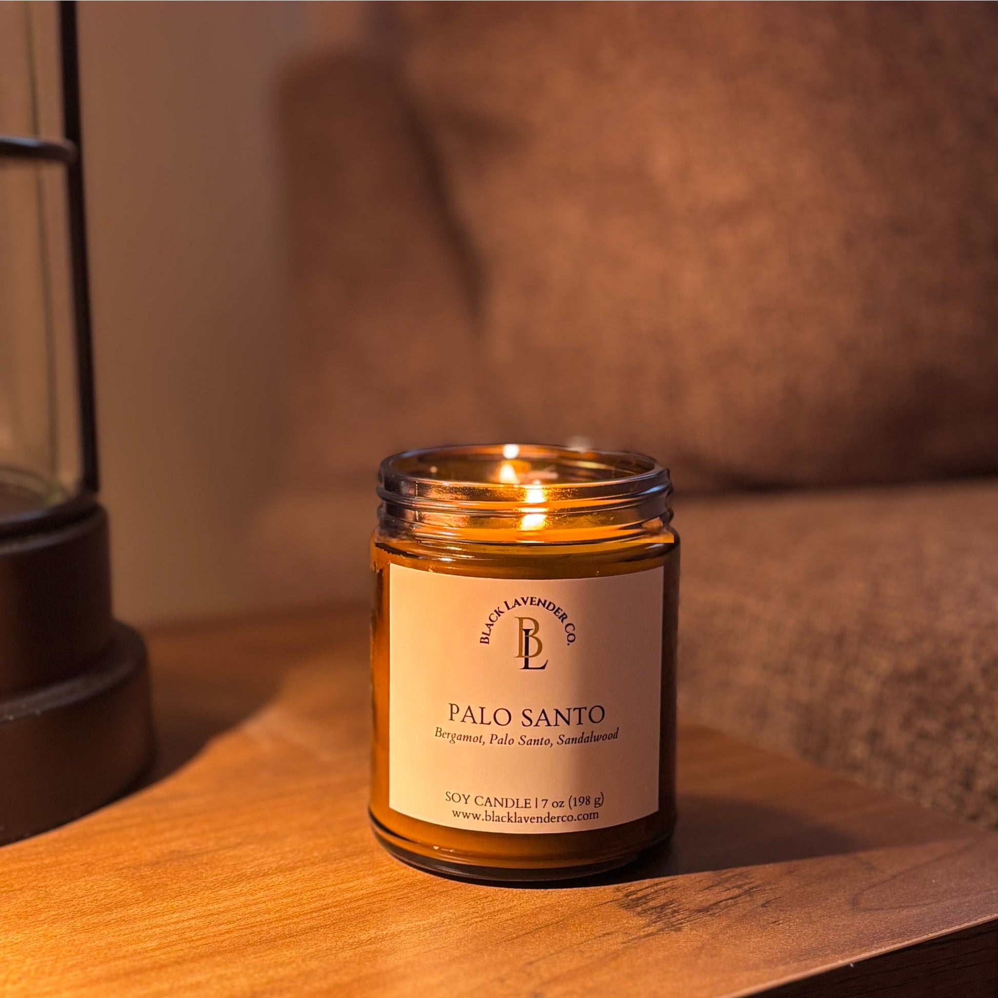 Palo Santo candle in a glass jar on a wooden surface with a lifestyle background